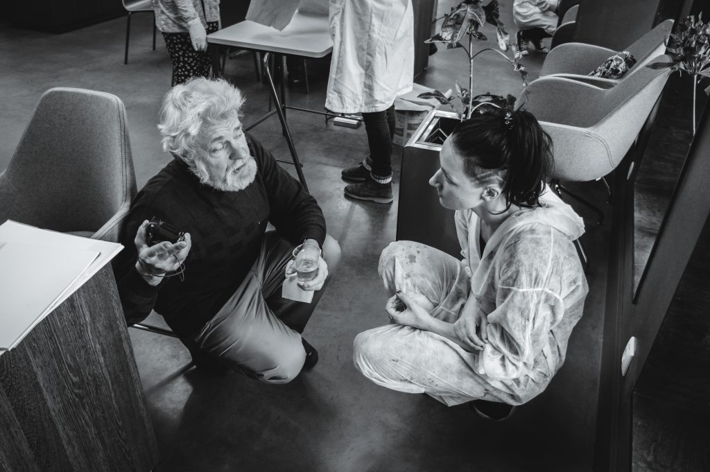 Macey Muse talking to a visitor at her art exhibition