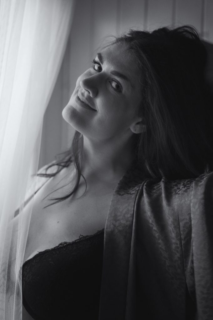 Woman by a window looking towards a camera
